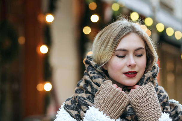 Весела блондинка носить зимове пальто і в'язаний шарф, що йде по місту. Порожній простір
 - Фото, зображення