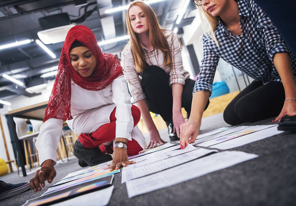 young black muslim businesswoman having meeting with her multiethnic startup business team in modern office interior,presenting new ideas on the floor - Foto, Bild