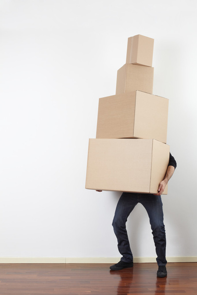 Man carrying cardboard boxes in interior - Φωτογραφία, εικόνα