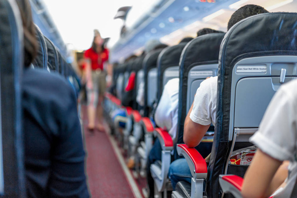 καθίσματα στο αεροπλάνο και επιβατών όλα καθιστικό που περιμένει το αεροπλάνο απογειώνεται από διάδρομο. - Φωτογραφία, εικόνα