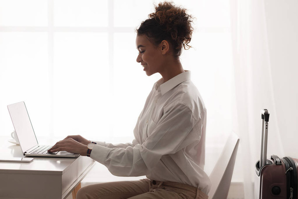Бізнес-леді працює на ноутбуці, готуючись до ділової поїздки
 - Фото, зображення