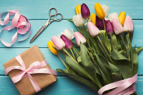 Colorful tulips bouquet and gift box on blue wooden background - Valokuva, kuva