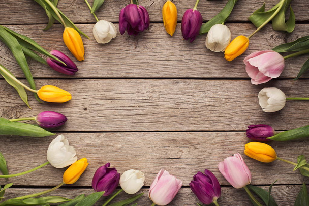 Круглая рамка из разноцветных тюльпанов на деревенском деревянном фоне
 - Фото, изображение