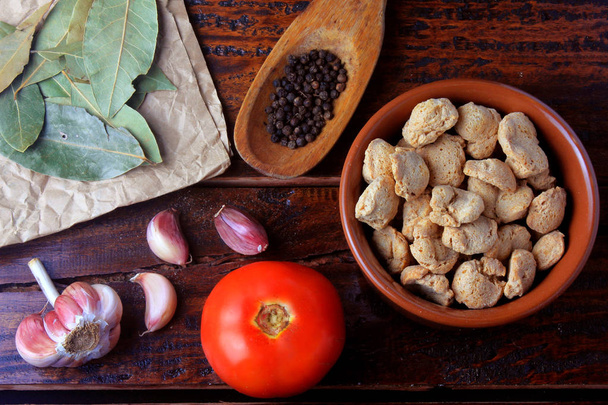 Soybeans meat, chunks in a brown ceramic bowl. Top view of raw soybeans chunks on rustic wooden background - Foto, Imagem