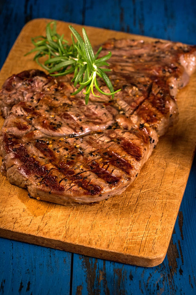 Steak grillé aux épices sur une table en bois bleu foncé
 - Photo, image