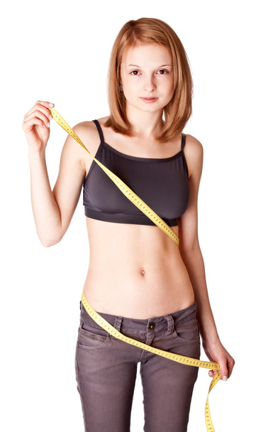 Young girl measures a waist - Φωτογραφία, εικόνα