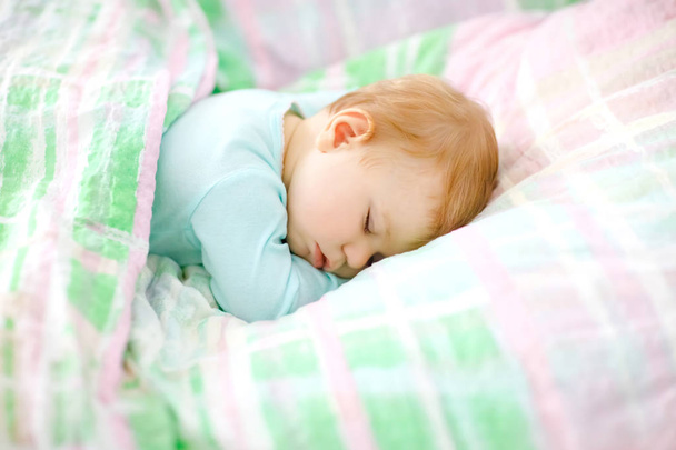 Adorable little baby girl sleeping in bed. Calm peaceful child dreaming during day sleep. Beautiful baby in parents bed. Sleeping together concept. - Photo, Image