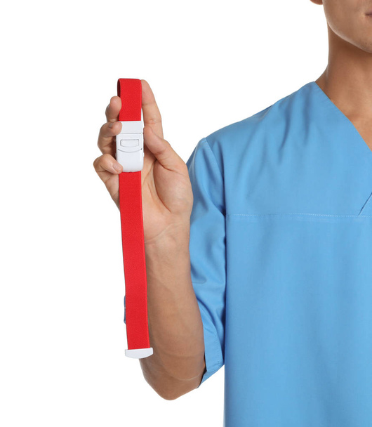 Male doctor holding tourniquet on white background, closeup. Medical object - Foto, immagini