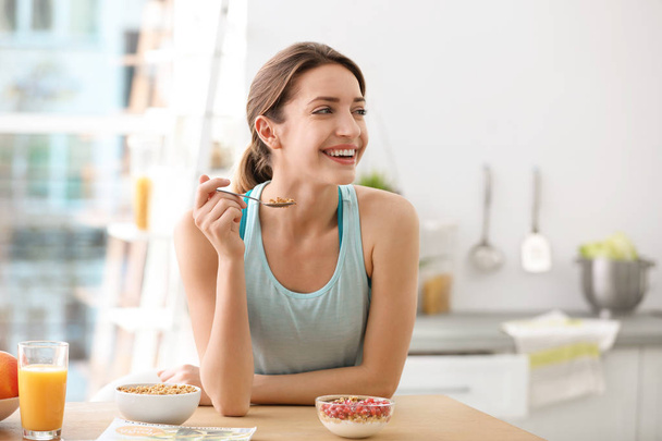Young woman in fitness clothes having healthy breakfast at home - Foto, immagini