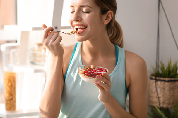 Young woman in fitness clothes having healthy breakfast at home - Fotografie, Obrázek