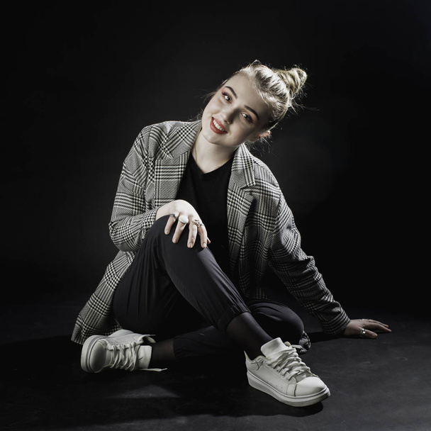 young girl in a gray jacket on a dark background in the studio s - Photo, image