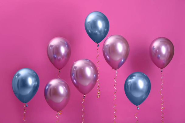 Bright balloons with ribbons on color background - Foto, immagini