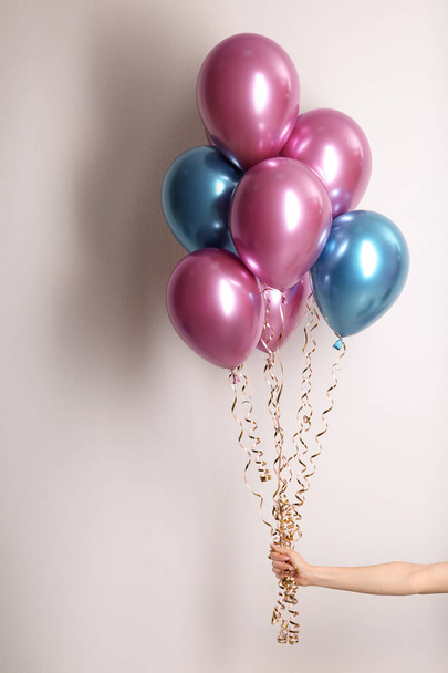 Woman holding bunch of balloons on white background, closeup - Foto, Imagen