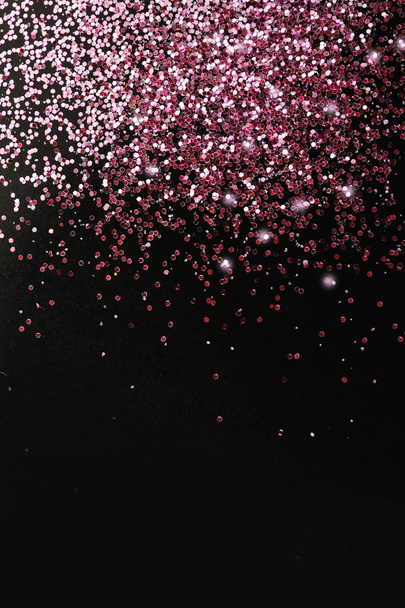 Rose gold glitter on black background, top view with space for text - 写真・画像