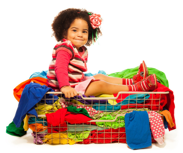 Black girl sitting in the basket with clothes - Fotoğraf, Görsel