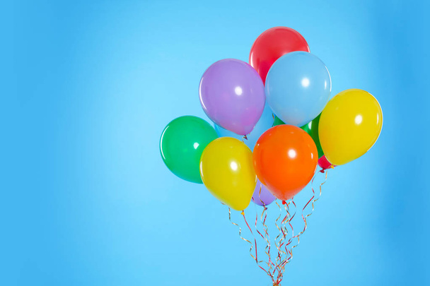 Bunch of bright balloons on color background. Space for text - Foto, Bild