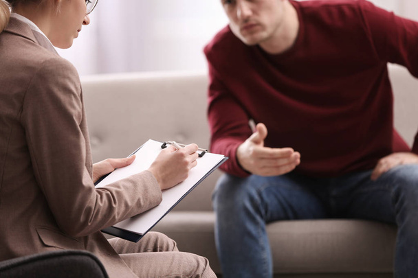 Psychotherapist working with young man in office, closeup - Photo, image