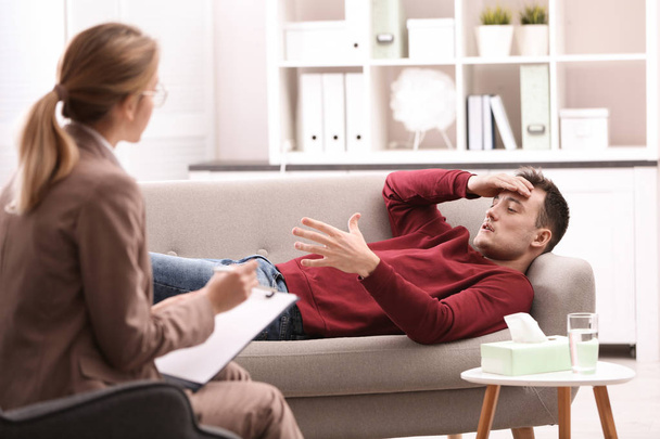 Psychotherapist working with young man in office - Foto, afbeelding