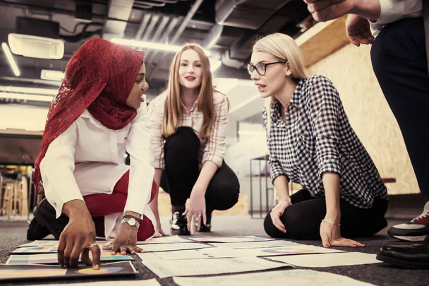 young black muslim businesswoman having meeting with her multiethnic startup business team in modern office interior,presenting new ideas on the floor - Valokuva, kuva