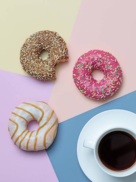 Bloco de cor flat lay com café preto e deliciosos donuts em cores pastel
 - Foto, Imagem