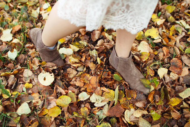 women's warm shoes in autumn leaves and grass - Φωτογραφία, εικόνα