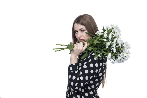 angry business woman with a bouquet of chrysanthemums on her shoulder isolated on white background - Valokuva, kuva