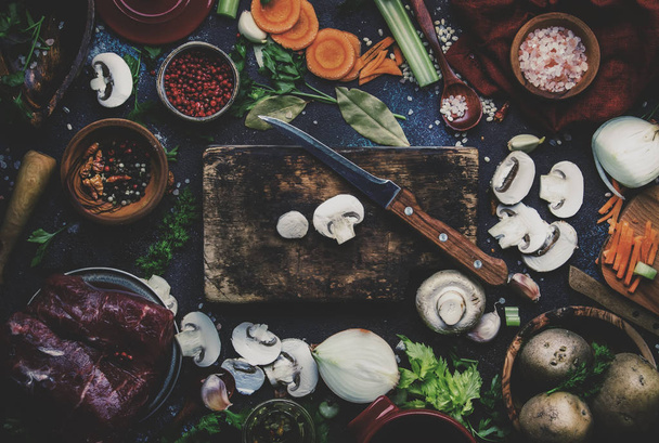 Tuoreet orgaaniset vihannekset, ainesosat, mausteet ja liha keittoon tai liemeen vintage-keittiön pöydän taustalla maalaismainen puinen leikkuulauta. Huippunäkymä, paikka tekstille. Terveellinen ruoanlaitto ja syöminen käsite
 - Valokuva, kuva