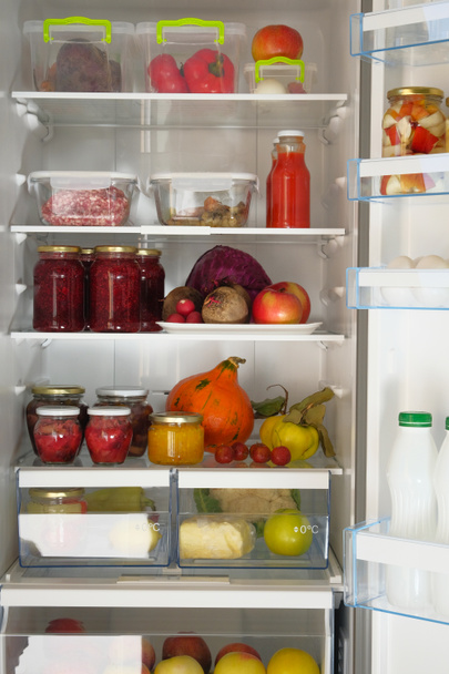 Im Kühlschrank stehen Gläser mit selbst gemachtem eingelegtem Gemüse und anderen Produkten. fermentiertes gesundes natürliches Ernährungskonzept. - Foto, Bild