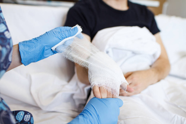 the nurse puts a bandage on the wrist of the patient - Foto, imagen