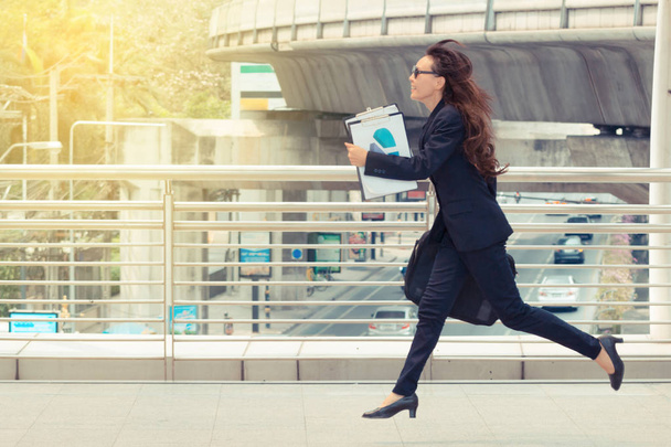 Blurred motion of Energetic business woman is running with carrying a briefcase to a business meeting. Competition concept. - Photo, Image