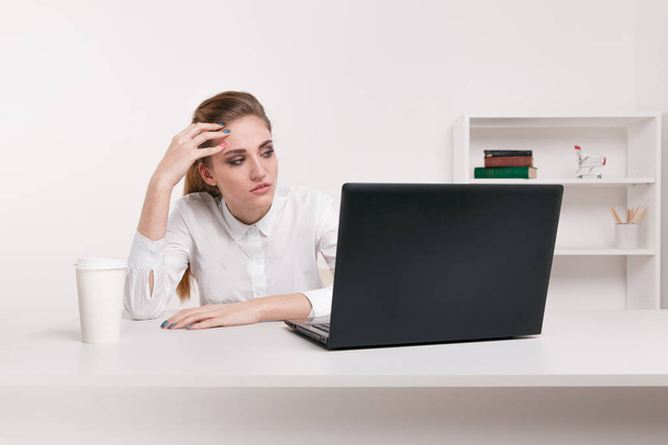 junge attraktive Frau an modernem Schreibtisch, arbeitet am Laptop, massiert Schläfen, um ständige Kopfschmerzen zu vergessen, lautes Büro, das eine Migräne verursacht, lindert Stress, chronische Schmerzen, hilft zu beruhigen - Foto, Bild