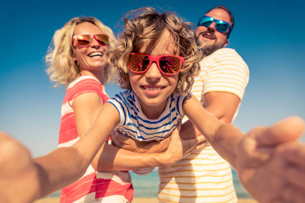 Happy family on summer vacation. People having fun on the beach. Active healthy lifestyle - Фото, изображение