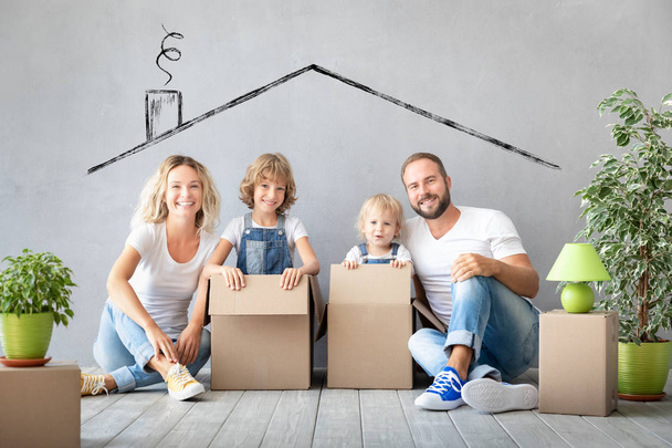 Happy family with two kids playing into new home. Father, mother and children having fun together. Moving house day and real estate concept - Foto, imagen