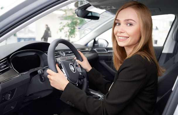 Female manager of dealership sitting in car drivers seat. - Photo, Image