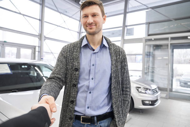 Hombre guapo, comprador de auto estrechando la mano con distribuidor
. - Foto, Imagen