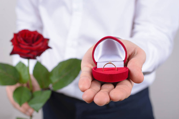 Návrh koncepce manželství. Oříznuté detailní Foto Open s krásný zlatý prsten s velkým kamenem, samostatný šedé pozadí - Fotografie, Obrázek