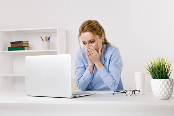 Exited woman surprised by something watching her laptop at office. - Foto, Bild