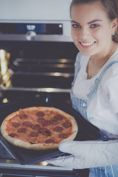 Happy young woman cooking pizza at home - Foto, immagini