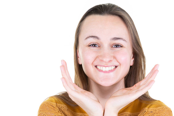 op witte achtergrond schattige glimlach jonge vrouw kijken naar de camera het verhogen van zijn handen op het gezicht - Foto, afbeelding