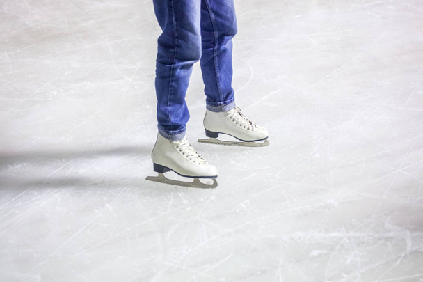 feet on the skates of a person rolling on the ice rink. - Photo, image