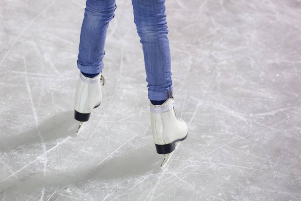 feet on the skates of a person rolling on the ice rink. - Foto, imagen