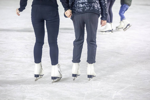 feet on the skates of a person rolling on the ice rink. - Zdjęcie, obraz