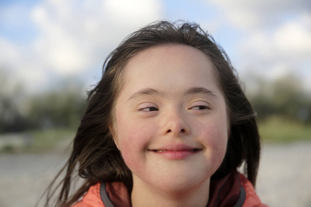Portret van een lachend meisje met het syndroom van Down - Foto, afbeelding