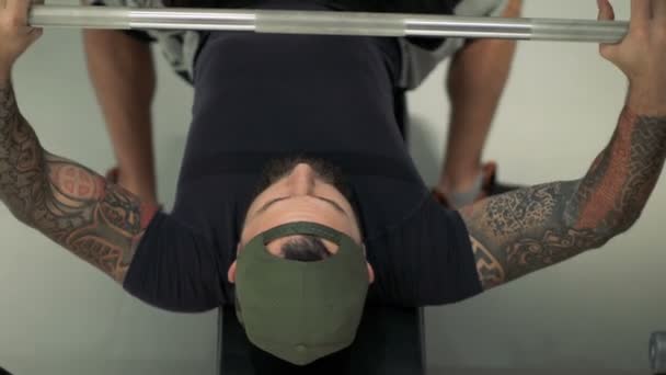 athlete performs a bench press barbell on the bench - Filmati, video