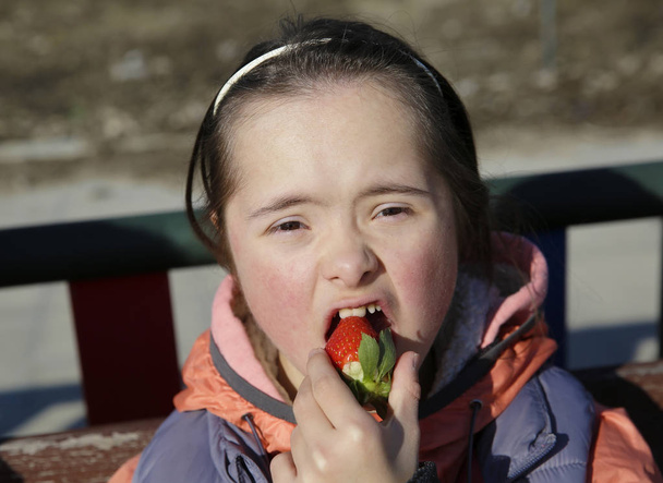 Retrato de una niña comiendo fresa
 - Foto, imagen