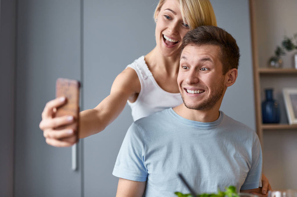 Smiling couple taking selfie at home  - Foto, imagen