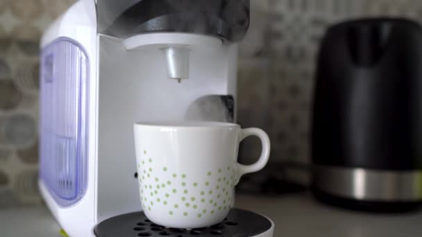 Kaffeemaschine für zu Hause bereitet eine Tasse frischen Kaffee zu. Dampfwolke am Ende des Kochens - Filmmaterial, Video