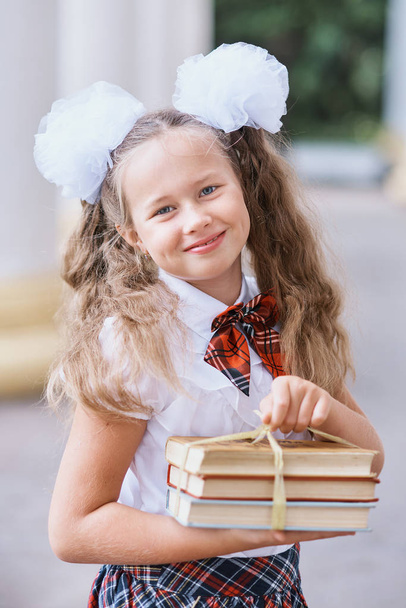 Portrait of beautiful young first-grader Farewell Bell. day of knowledge. beginning of the school year. Happy schoolgirl standing with book in hands. Child enjoy study and reading - Fotoğraf, Görsel
