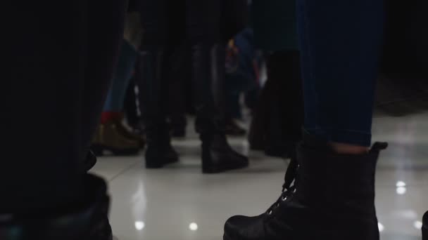 Nohy z davu lidí čekání na odbavení na letišti nebo v hotelu, do fronty k bance - Záběry, video