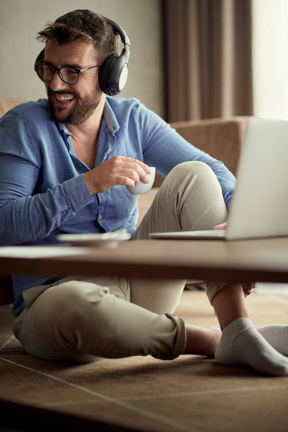 Concept of young people working at home- Smiling man uses a laptop - Foto, Imagem